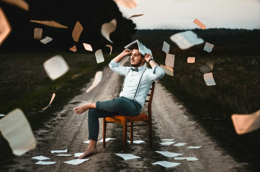 man sitting on chair with book: A learning industry that doesn’t know how to learn? How did we get here?