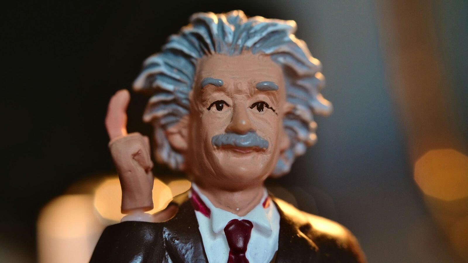 man in black suit jacket figurine: Genius
