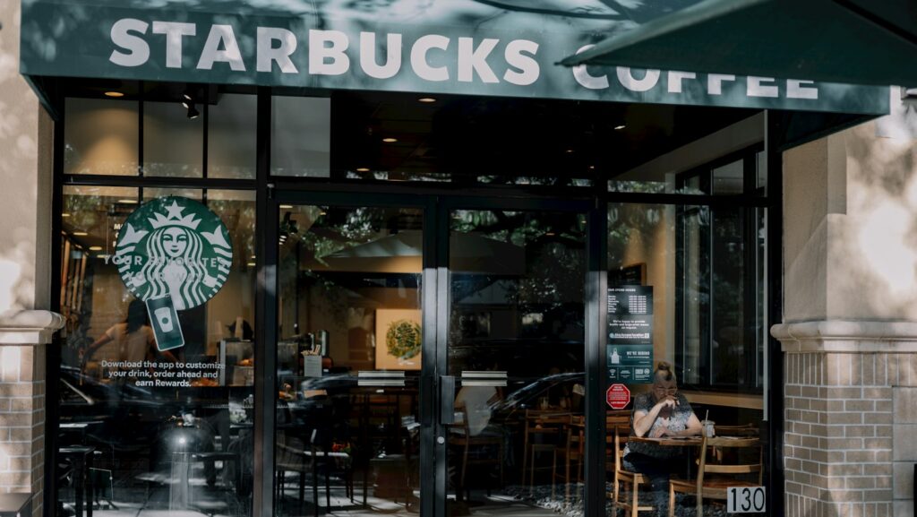 a starbucks coffee shop with a person sitting at a table: leader