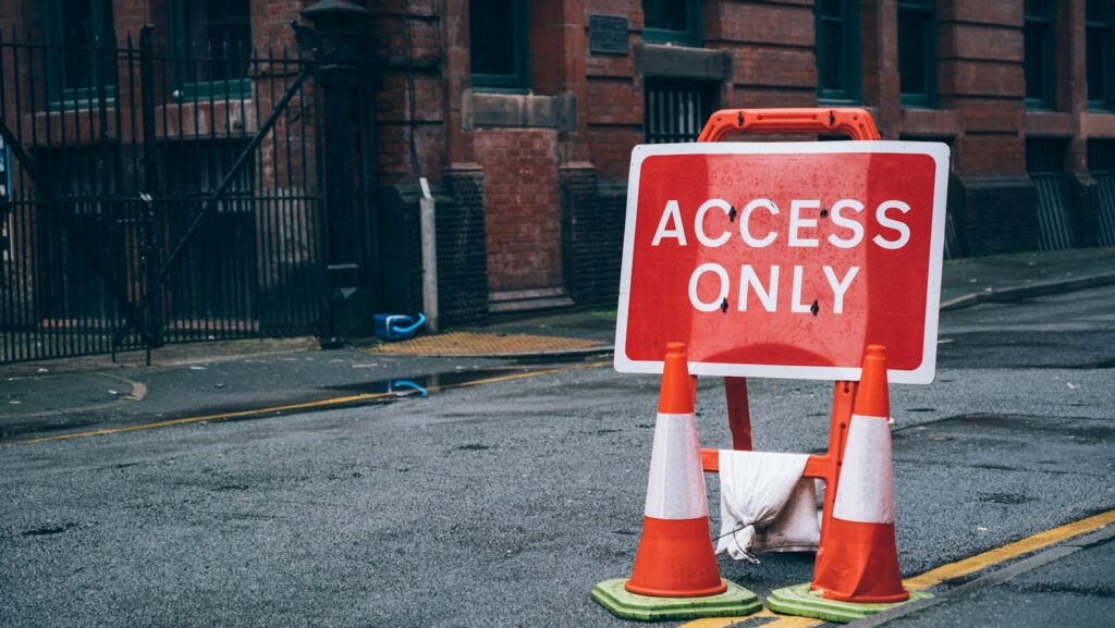 a red and white sign sitting on the side of a road