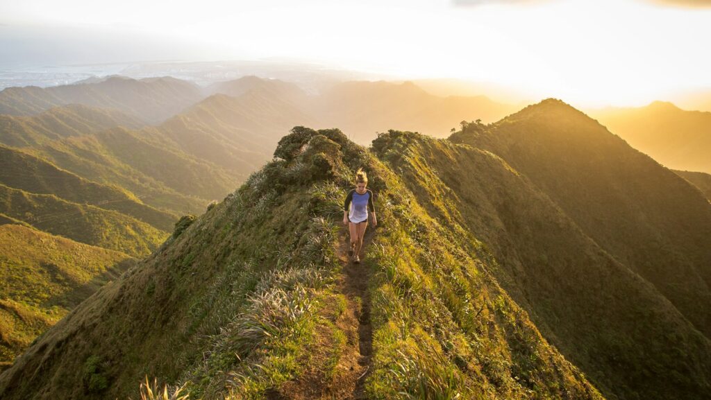 woman walking on pathway on top of hill at golden hour, behaviour change