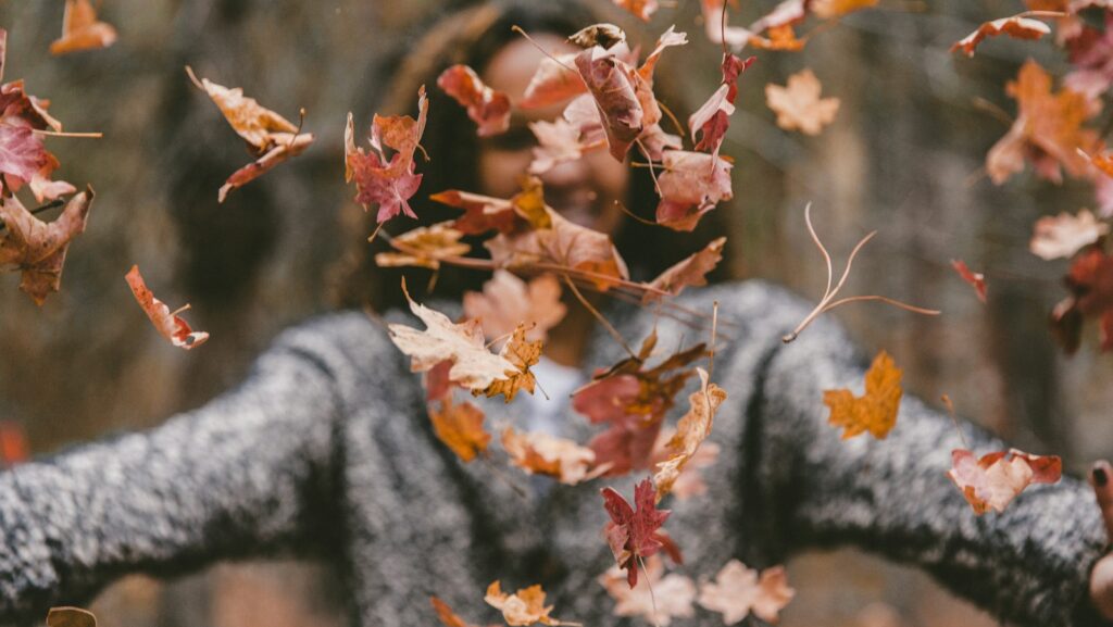 woman throwing maple leaves, menopause