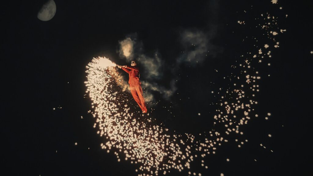 person in red jacket and blue denim jeans standing on white snow covered ground during night