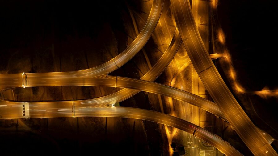 an aerial view of a highway intersection at night, adaptability