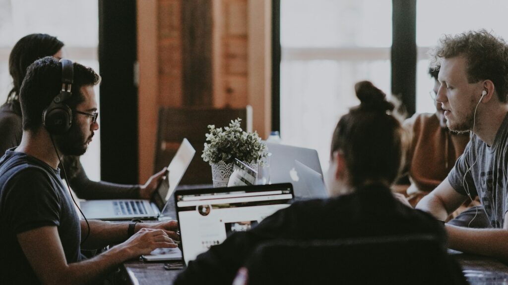 selective focus photography of people sits in front of table inside room