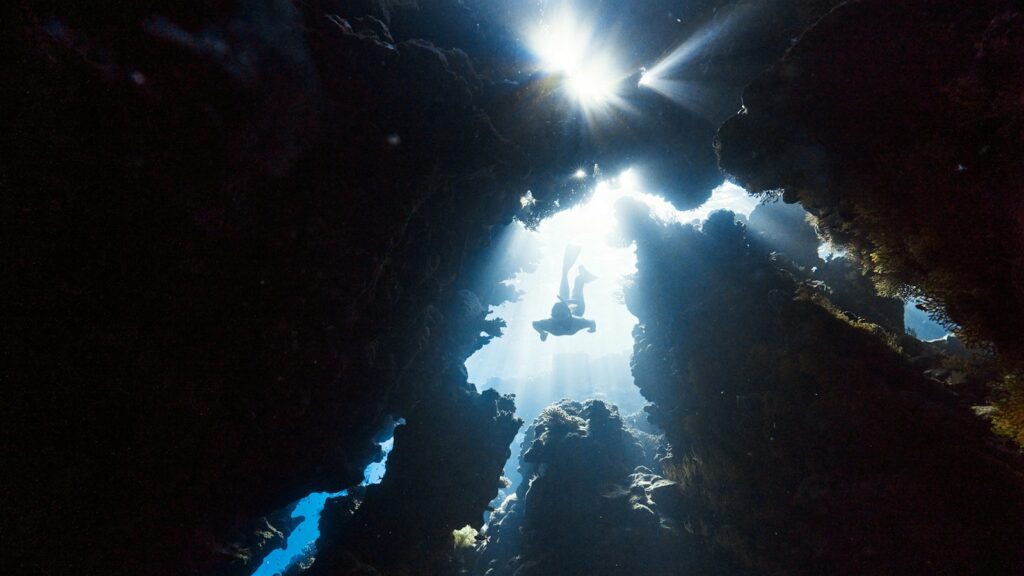 the sun shines through the water in a cave