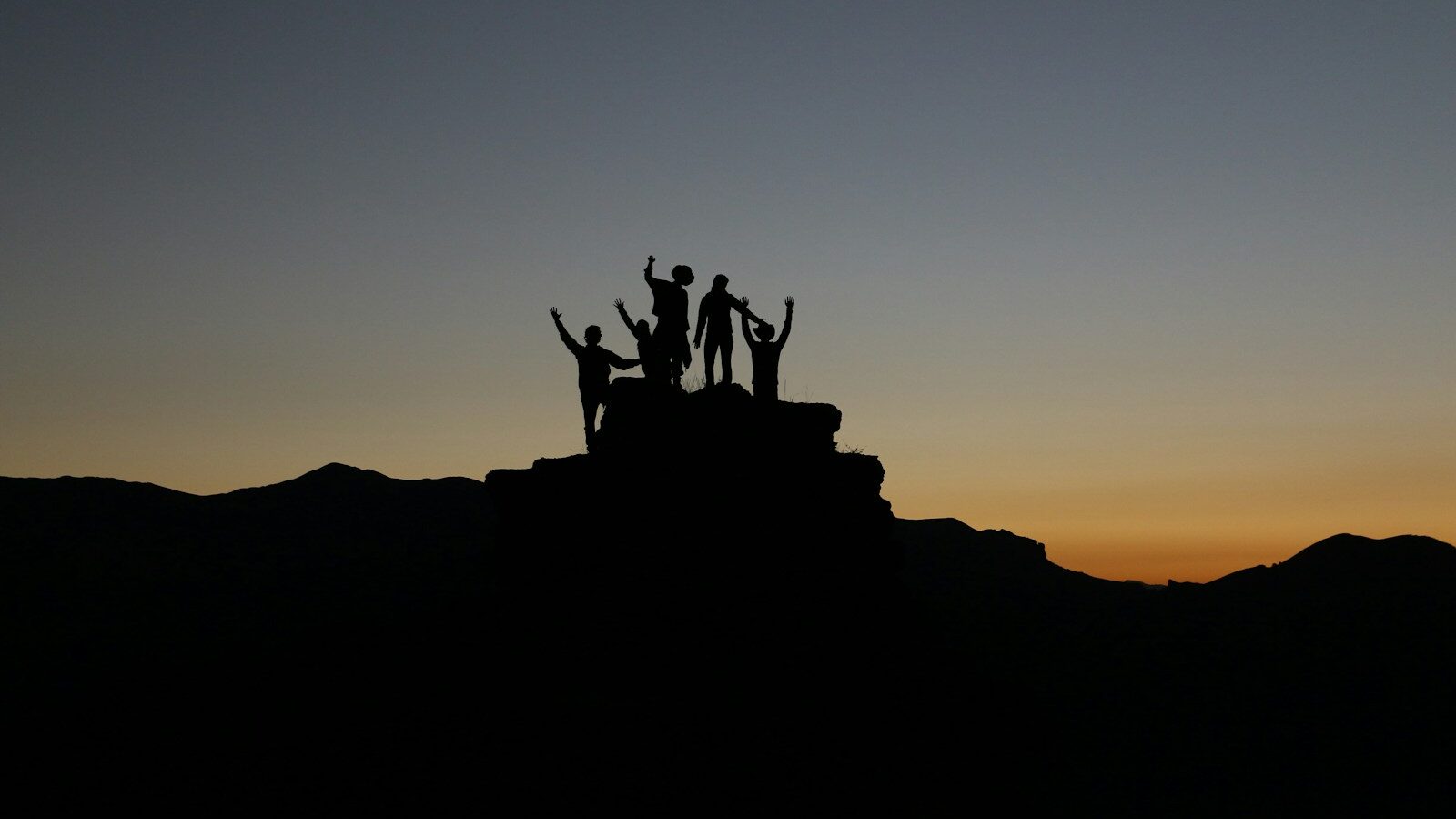 silhouette of people standing on highland during golden hours