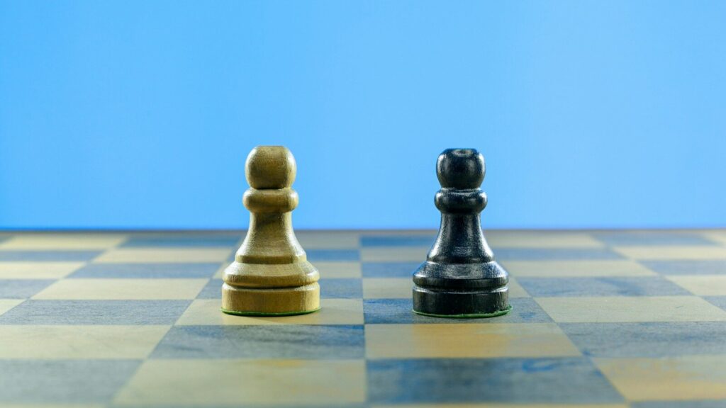 a black and a white chess piece on a checkered board